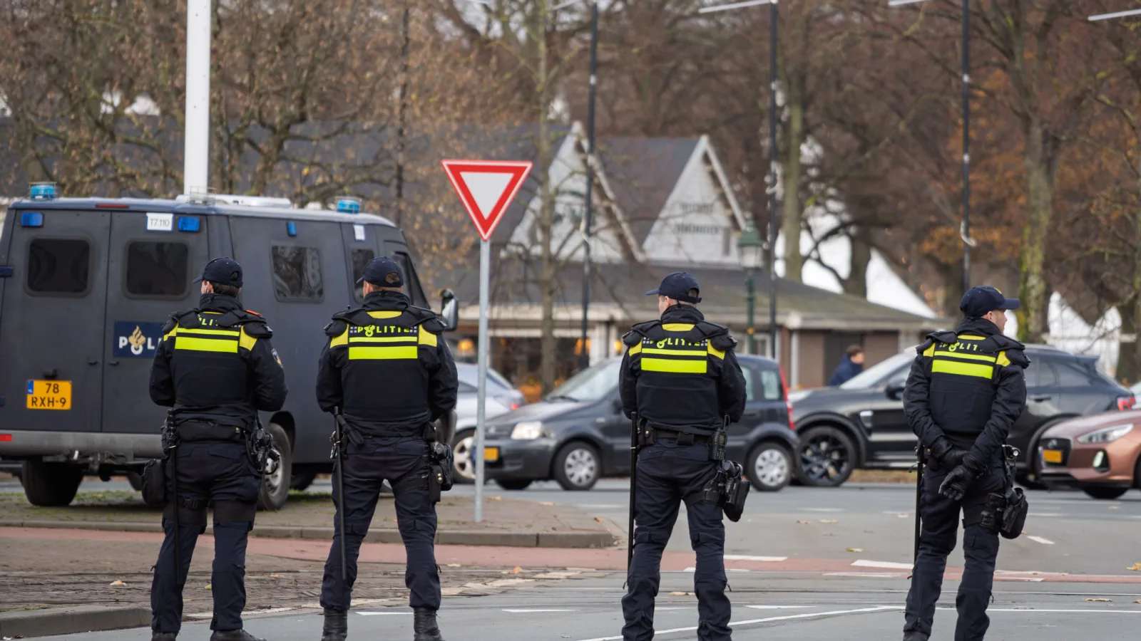 Patru polițiști în uniformă, așteptând lângă o autospecială
